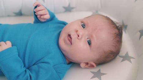 cute small child lies on star patterned cocoon in light room