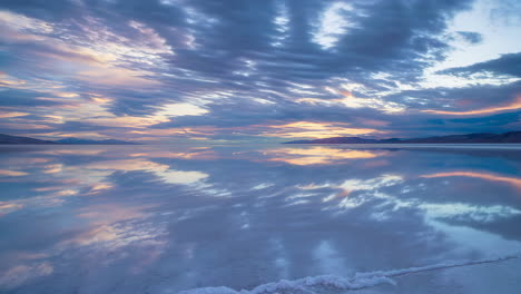 sunrise or sunset over a calm salty lake with mirrored skies