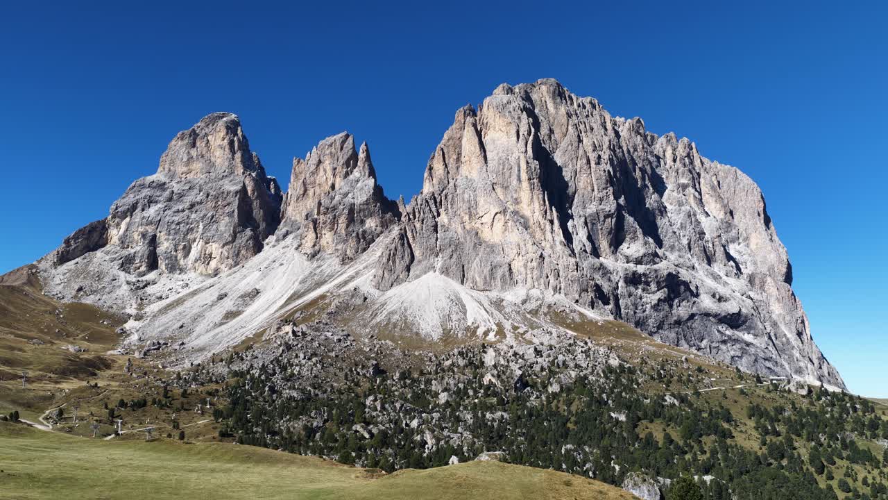 Aerial drone video featuring a mountain ridge in the Italian Dolomites during late summer daytime