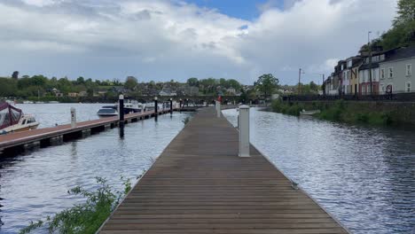 POV-walking-on-floating-pier-on-river-in-Killaloe-near-old-arch-bridge