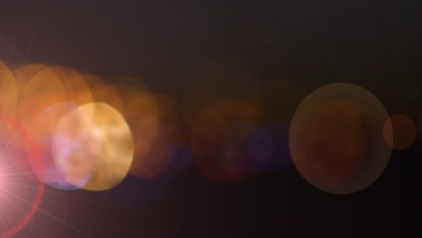 Orange-glowing-spots-of-light-against-black-background