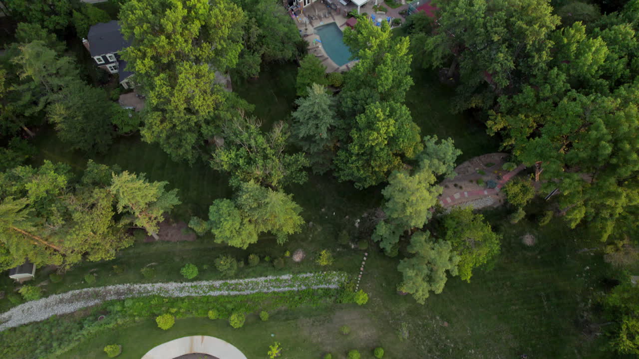 antena sobre un pequeño parque con una inclinación hacia arriba para revelar un hermoso vecindario a la hora dorada en el verano en la ciudad y el campo en st.
