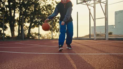 Ein-Blondes-Mädchen-In-Einer-Sportuniform-Manövriert-Mit-Dem-Ball,-Der-Ihn-Während-Ihres-Basketballspiels-Auf-Dem-Red-Street-Court-An-Einem-Sommermorgen-Vom-Boden-Abprallen-Lässt