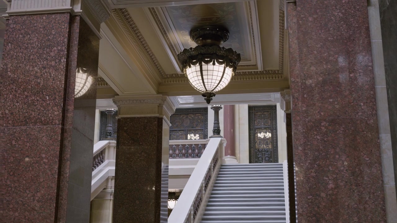 Ripresa cinematografica con gimbal e dolly da destra a sinistra all'interno del Campidoglio dello Stato del Wisconsin, con scalinata e illuminazione e un movimento fluido della telecamera.