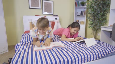 two friends study in bed at home.