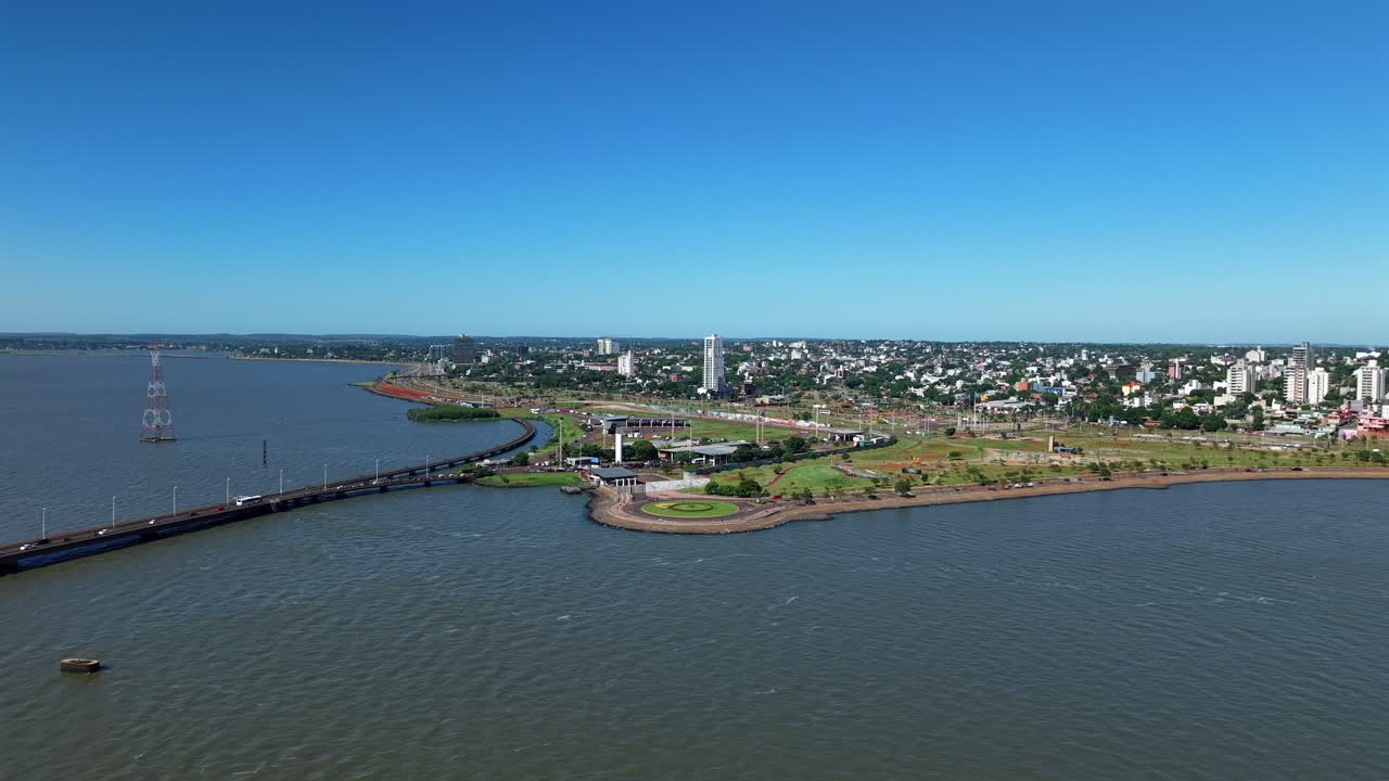 Panorama aereo dell'ansa del fiume Paraná con il Ponte San Roque González de Santa Cruz o Ponte Internazionale che espande il lungofiume urbano, Posadas, Misiones, Argentina