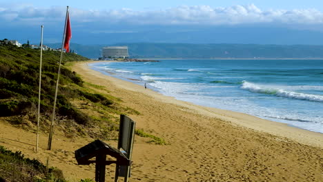 Person-walking-on-vast-stretch-of-pristine-sandy-beach