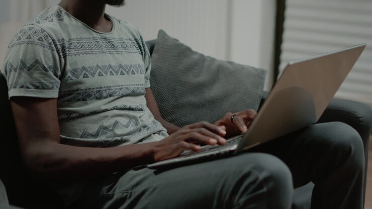 Close up of black person typing on laptop keyboard