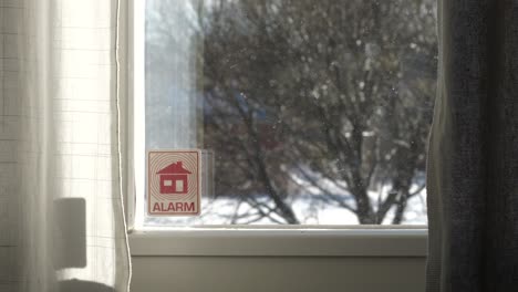 home security alarm sign on window of domestic house, criminality on the rise