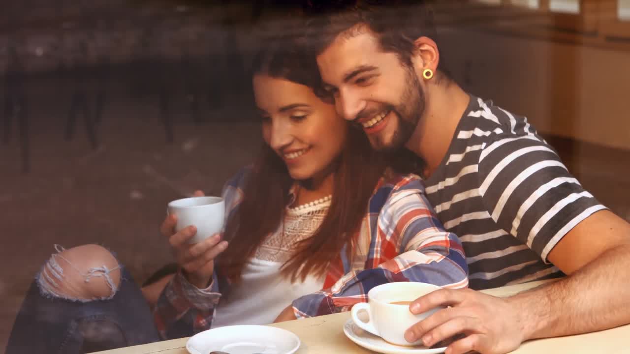 pareja feliz interactuando entre sí mientras toman café