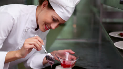 un chef feliz vertiendo jarabe sobre una bandeja de merengues