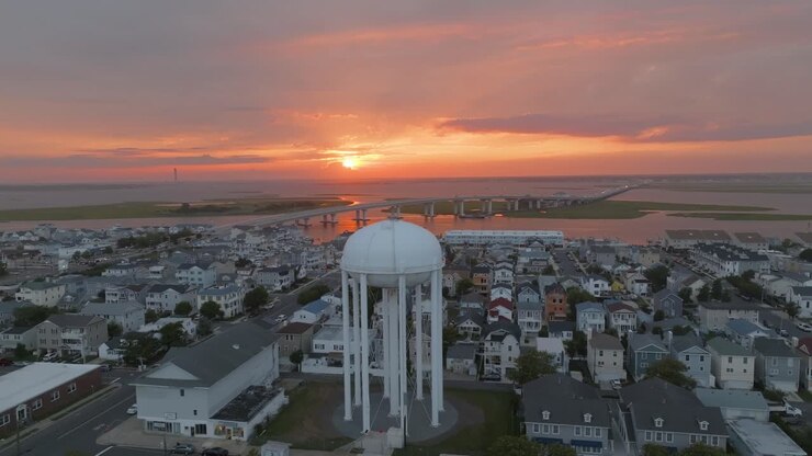 Splendido tramonto con la torre dell'acqua e il ponte della 9a Strada nell'inquadratura a Ocean City, New Jersey