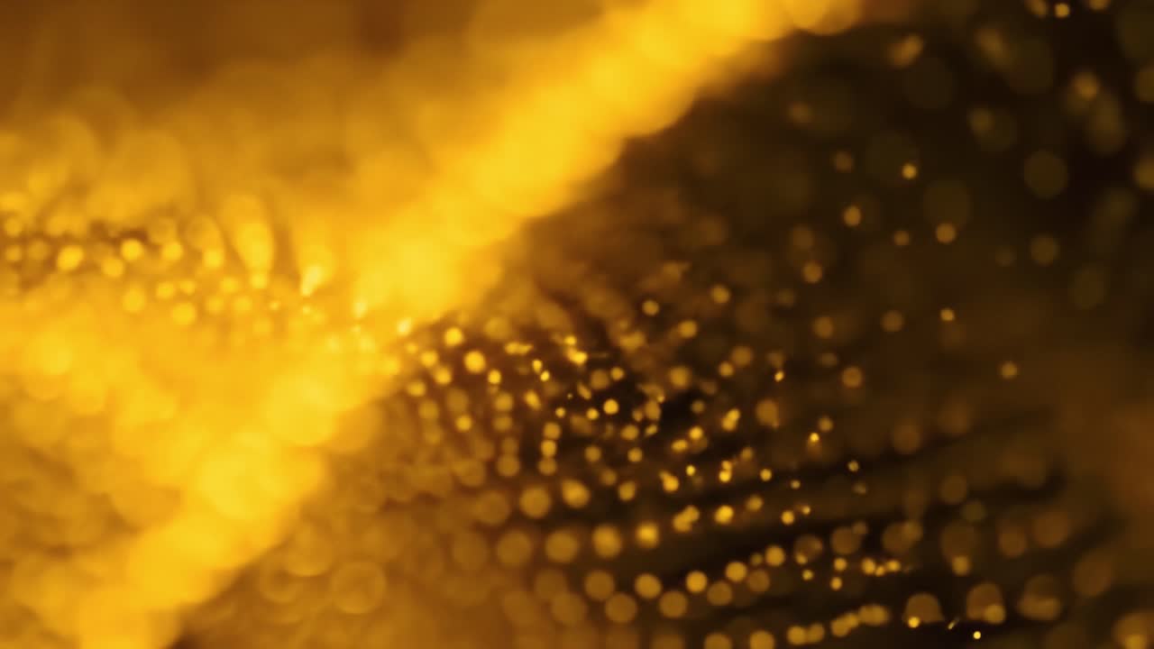 Golden liquid creates a mesmerizing flow as light dances on its surface, showcasing exquisite drops and reflections in a serene atmosphere.