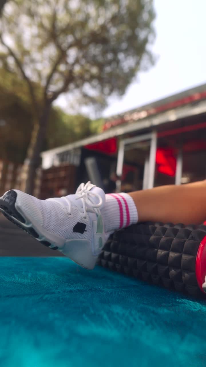 mujer que usa un rodillo de espuma para estirar las piernas