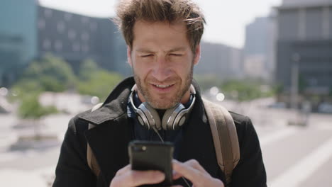 portrait of handsome young caucasian man texting browsing using smartphone social media app enjoying mobile communication in sunny urban city