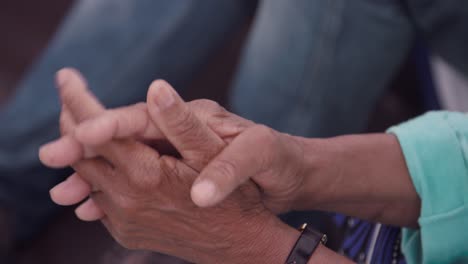 elderly woman's clasped hands - close up, high angle