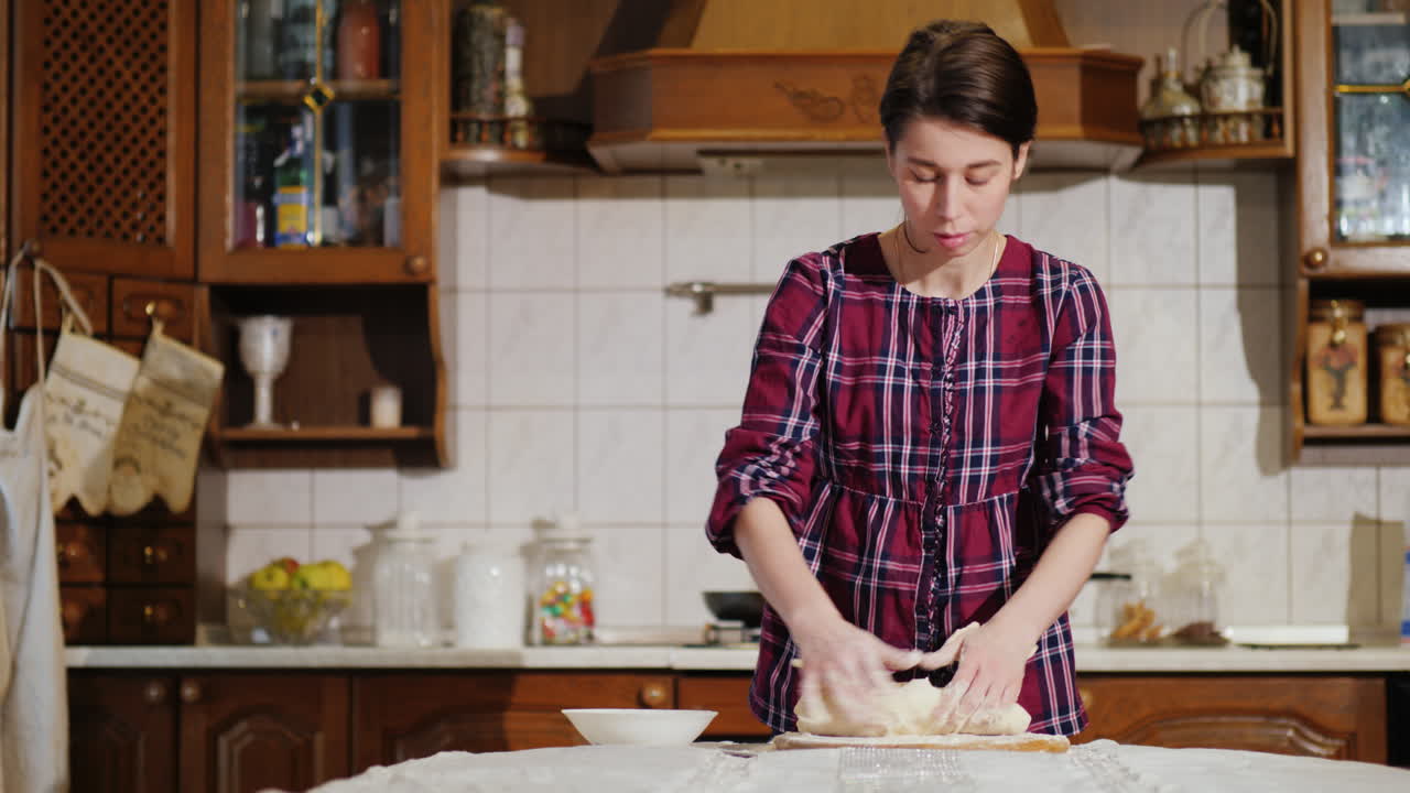 una mujer amasando masa de pizza en su cocina video 4k