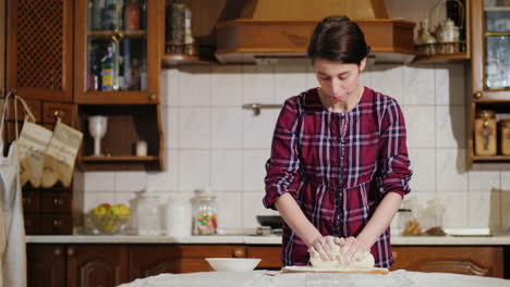 una mujer amasando masa de pizza en su cocina video 4k