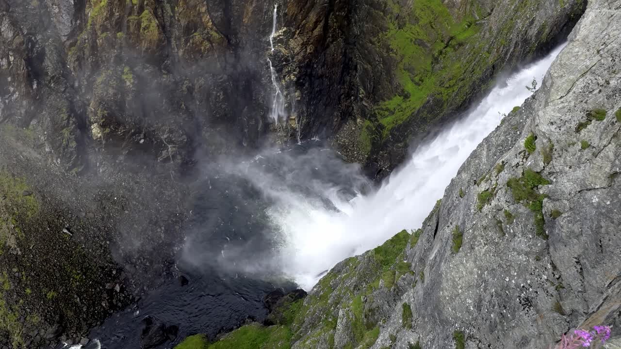 Slow motion view down Voringfossen and canyon, panning across valley as river flows through Mabodalen towards Eidfjord