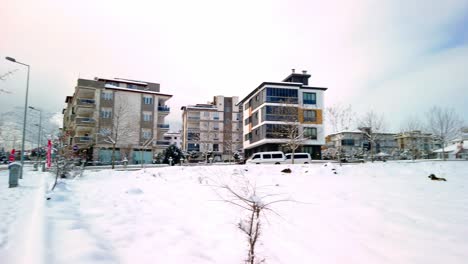 View-of-a-snow-covered-ground-surrounded-by-residential-multi-storied-buildings-on-all-sides-in-Denizli-city,-Turkey-during-winter-season-on-a-cloudy-day