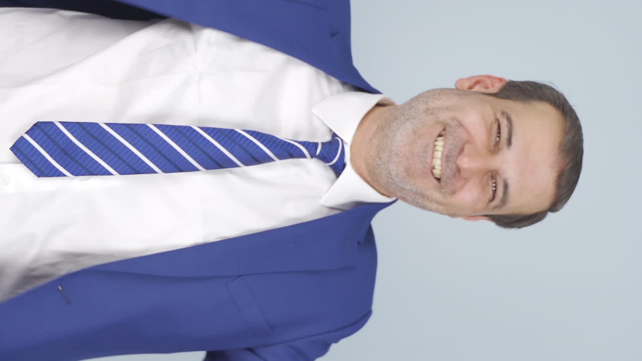 video vertical de un hombre de negocios haciendo corazón a la cámara.