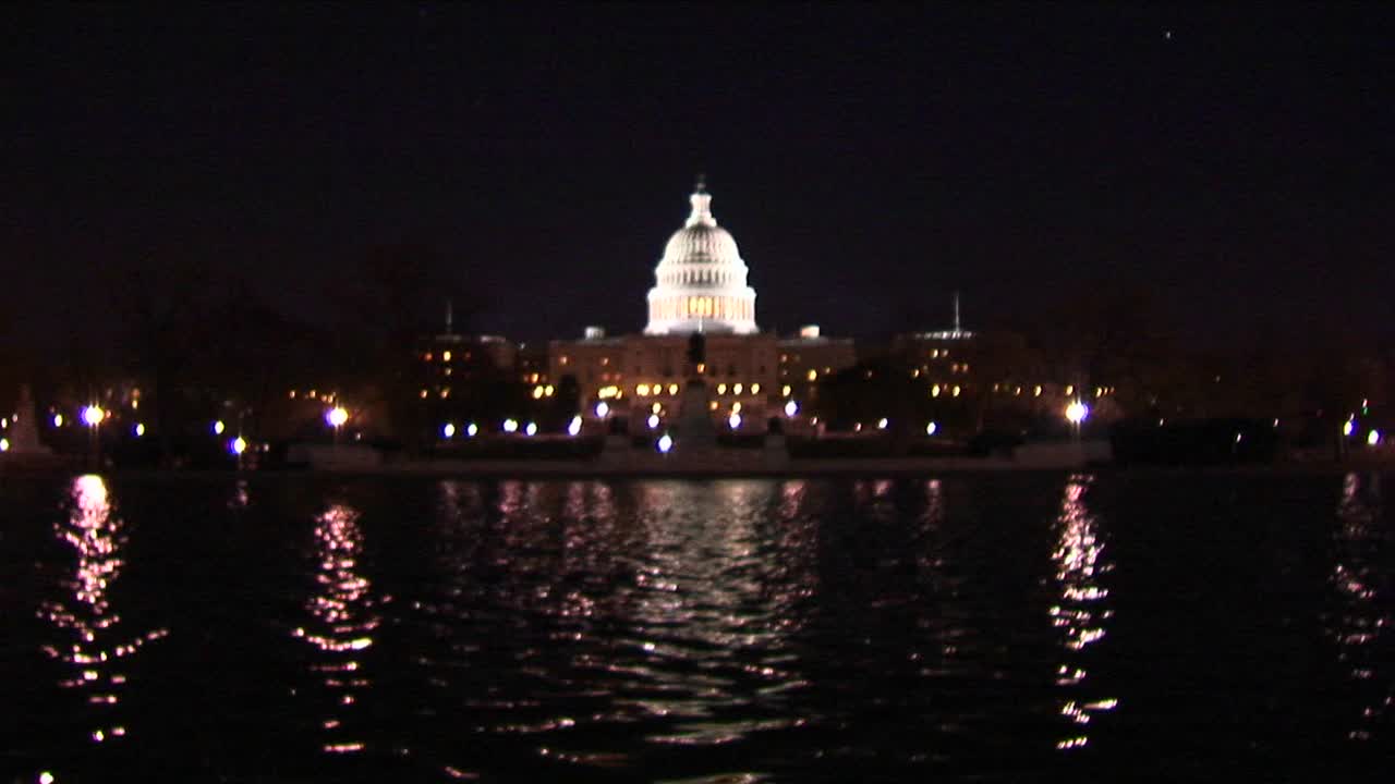 반사 풀이 아래에서 반짝임으로 국회 의사당 돔이 조명됩니다.