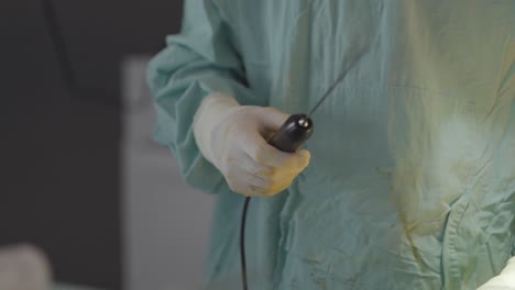 plastic surgeon holding a fat aspiration catheter, showcasing the specialized tools used in cosmetic procedures for precise fat removal