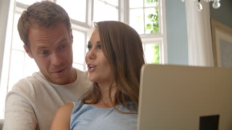 couple relaxing on sofa using laptop computer shot on r3d