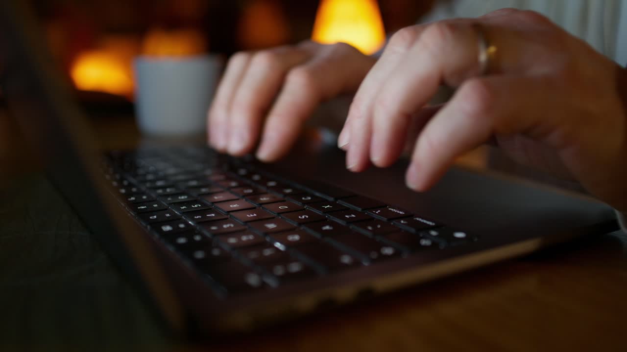 persona escribiendo en la computadora portátil por la noche