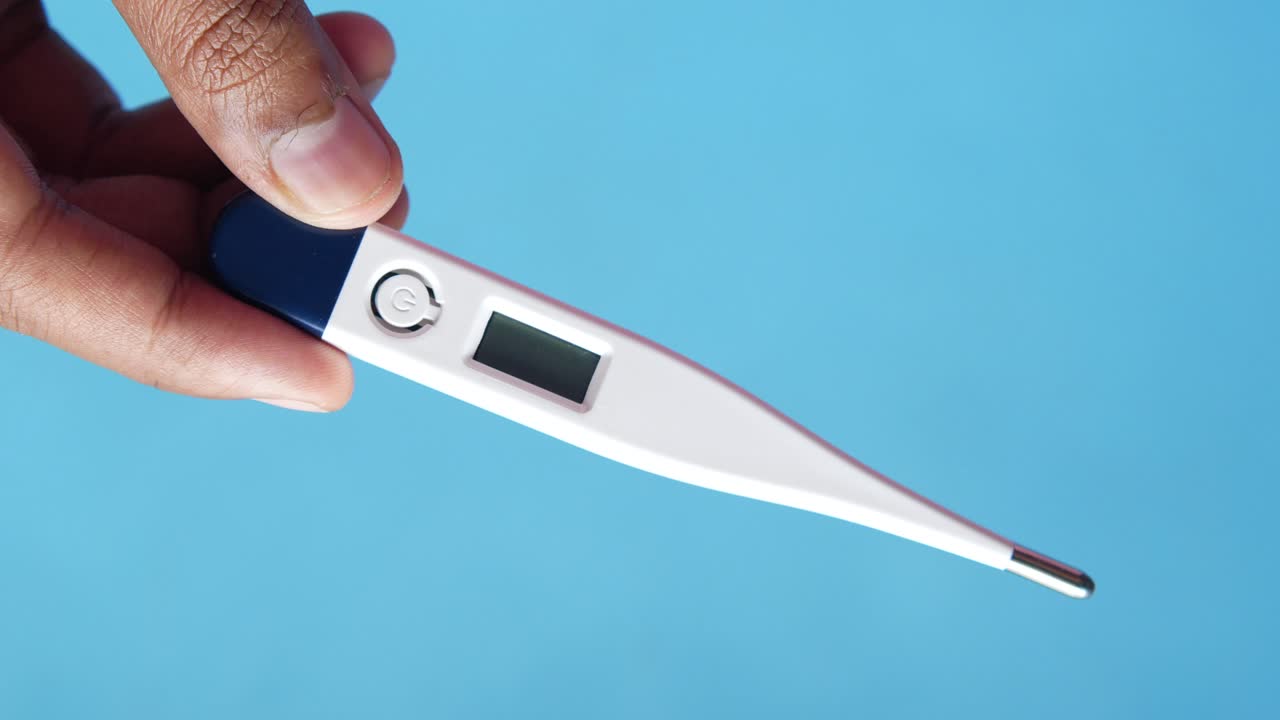 디지털 온도계를 들고 있는 손