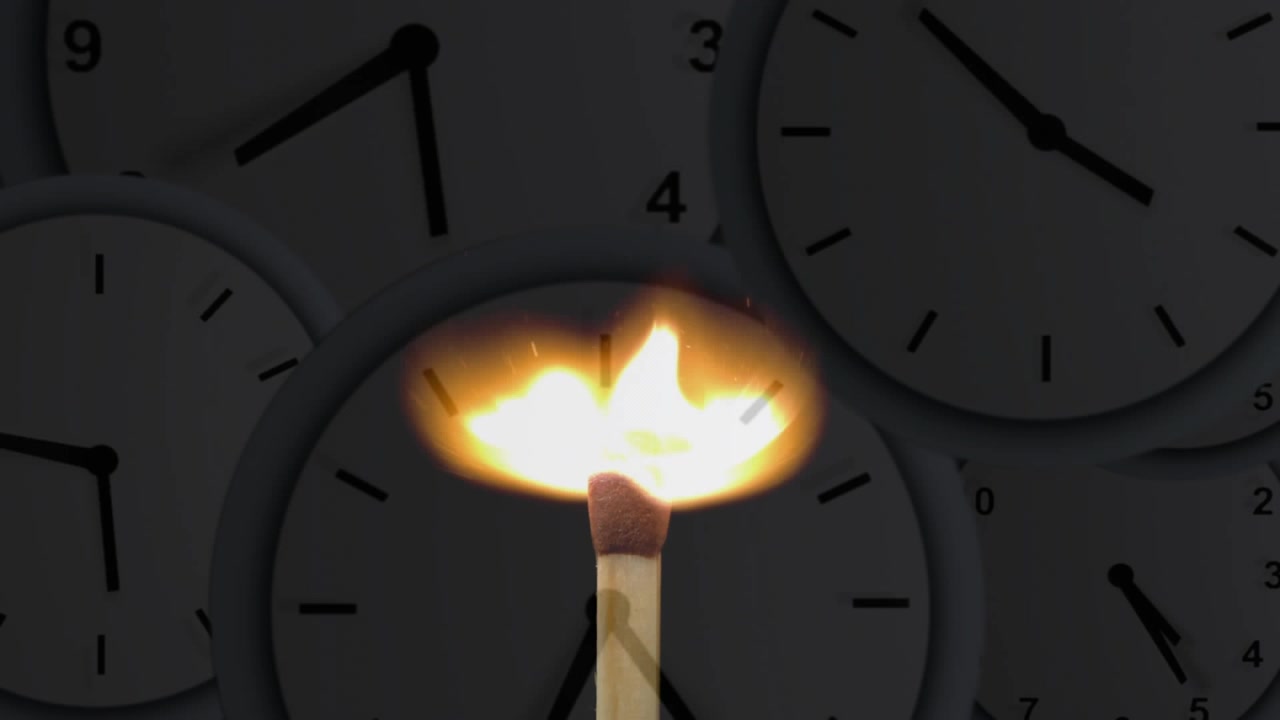 Fiammifero di legno che scintilla, brucia e si trasforma in ali di fiamma che spazzano quadranti di orologi fiocamente illuminati, mostrando l'ora