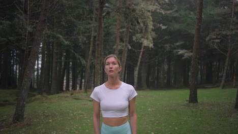 mujer atractiva perdida con ropa deportiva que parece asustada en el místico bosque cambiante