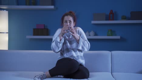 la mujer cobarde bebe agua con la mano temblorosa.
