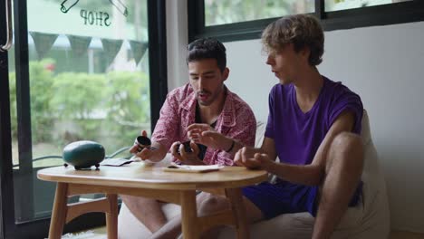 Two men sitting at a table having a conversation in a cafe
