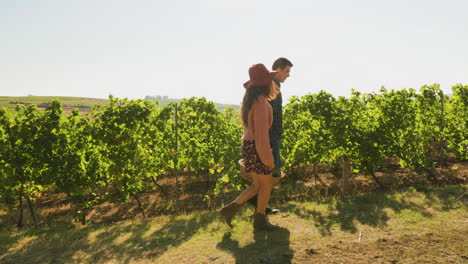 pareja llevando una gran canasta con uvas blancas en un hermoso viñedo