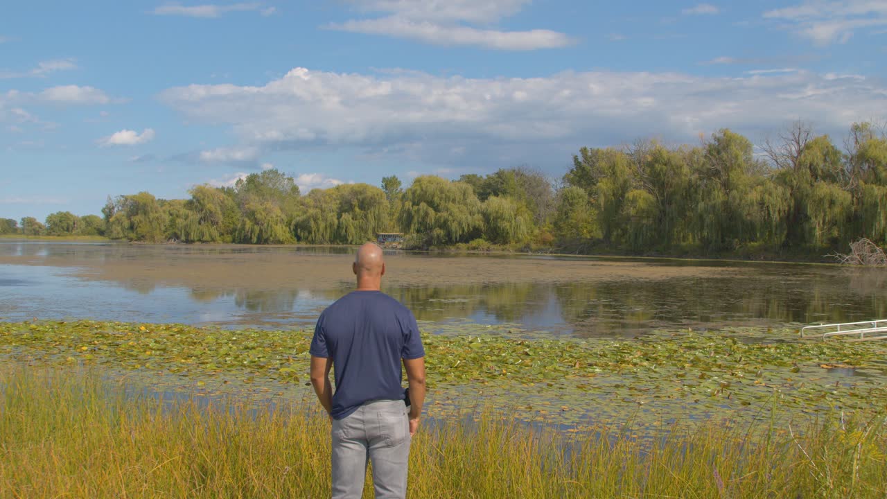 Light skin Black male walking up to lake taking in the view