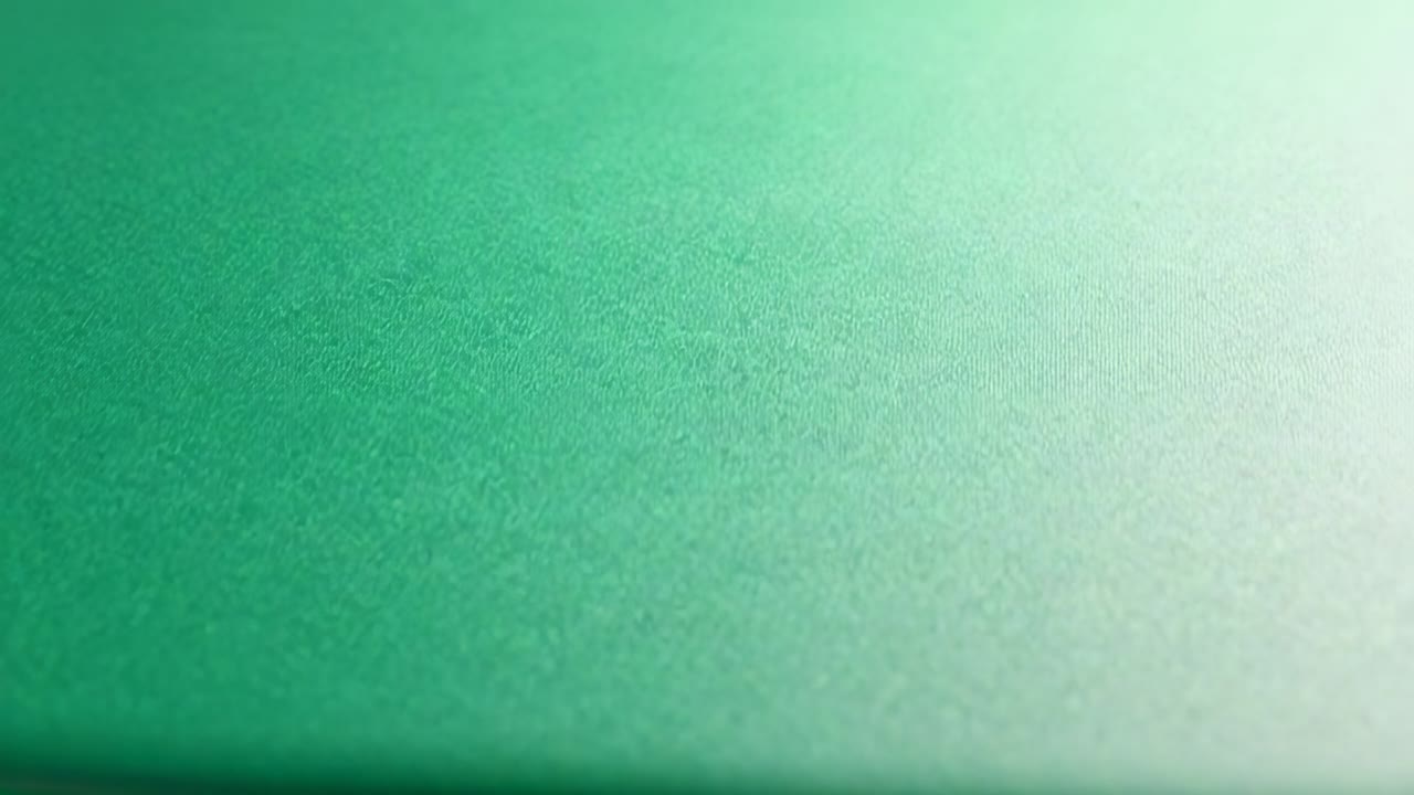 Câmera gravando, capturando um plano verde em close-up, ajustando o foco, a emenda desbotando e revelando a textura.