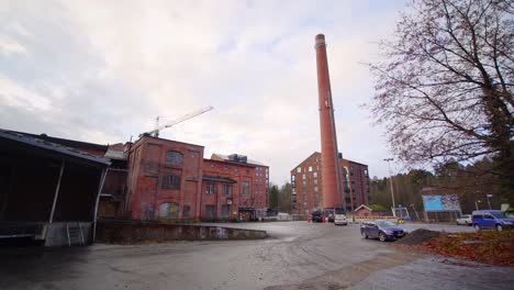 modern apartment building and a chimney on the yard of an old factory district