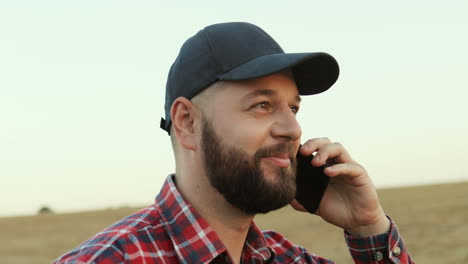 close up of farmer talking on the phone while walking in the field