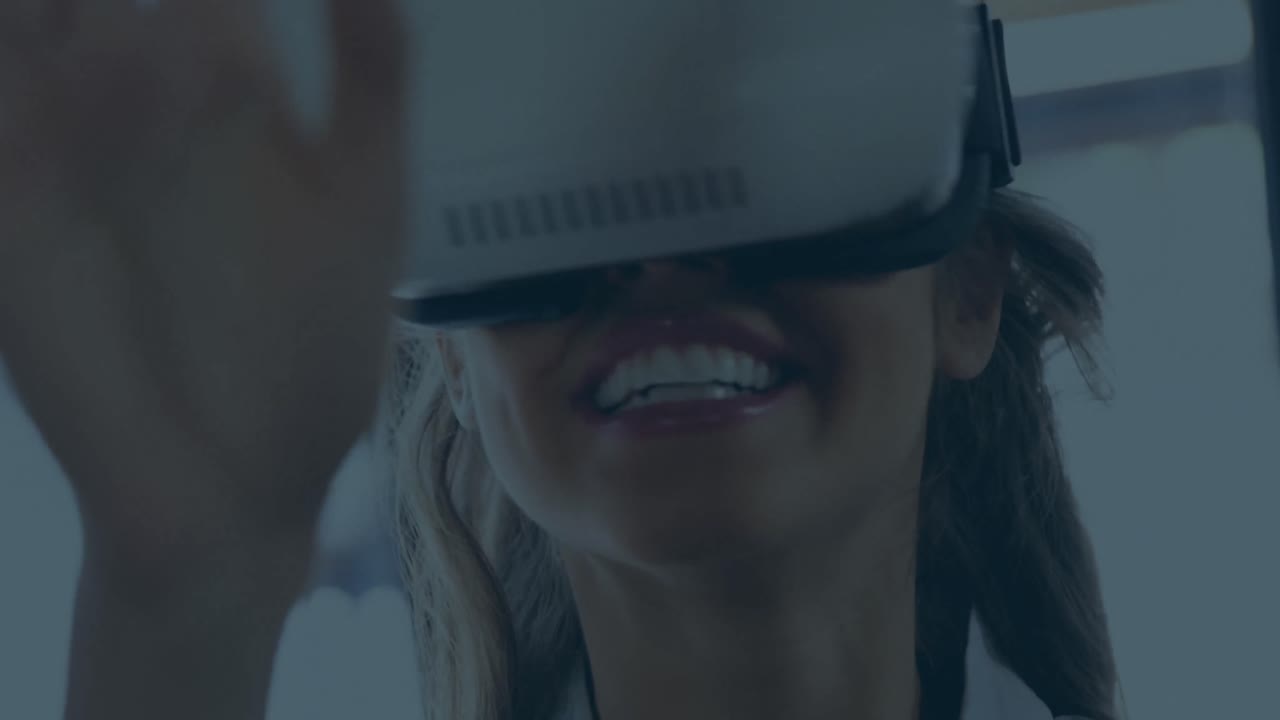 Animazione di forme geometriche multicolori su donna d'affari caucasica sorridente che usa un visore VR