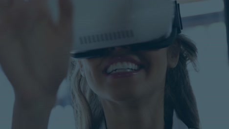 animation of multicolored geometric shapes over smiling caucasian businesswoman using vr headset