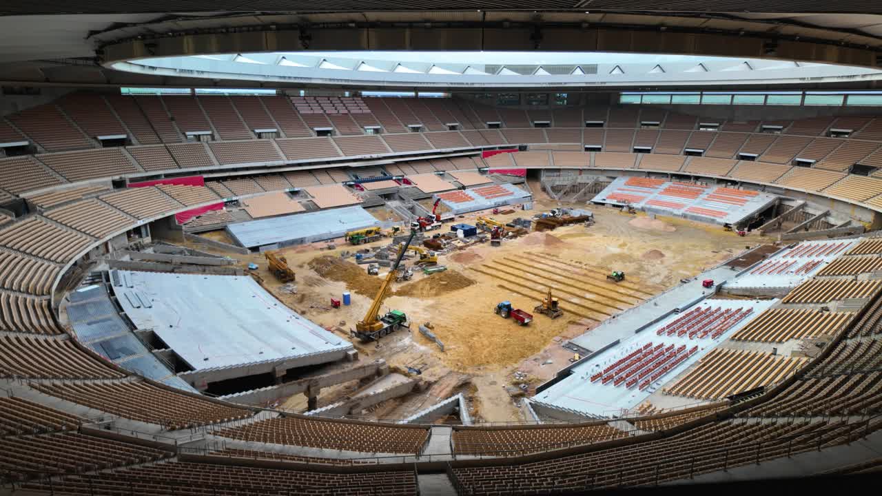 Vehicles dig and transport earth in Sevilla stadium renovation