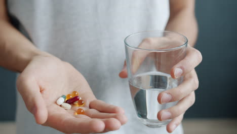 person holding pills and water