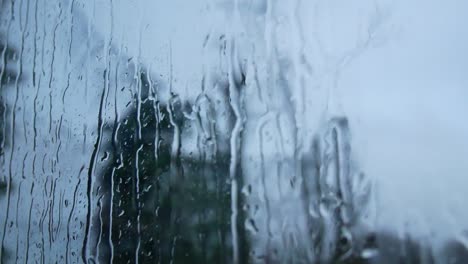 rainy storm droplets, moody weather fall down window glass closeup bokeh