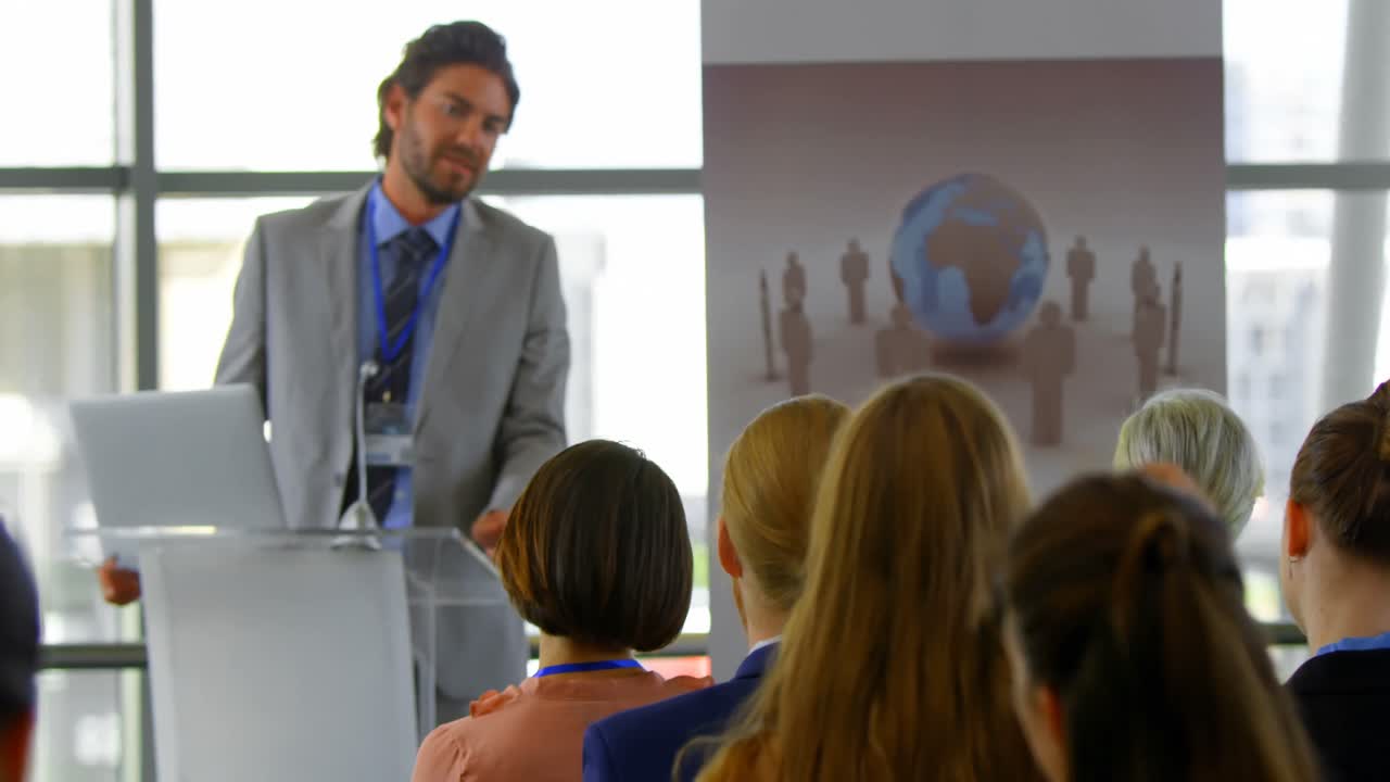 orador interactuando con una mujer de negocios en el seminario de negocios 4k