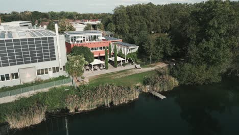 drone flies to the right horizontal curve over lake in germany with restaurant in view