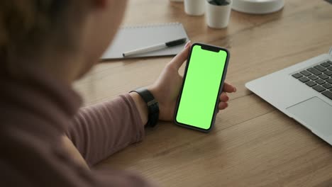 woman video chatting using mobile phone with green screen