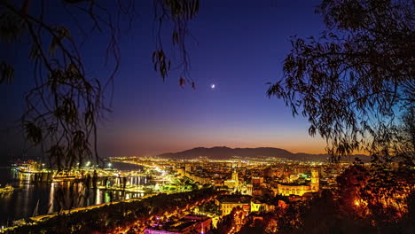 lapso de tiempo nocturno de la luna creciente en el puerto de málaga, españa