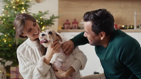 Multi-ethnicity-couple-bonding-with-dog-at-Christmas-time.