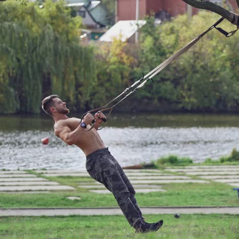 . training in open air. young man working out by the lake in city park